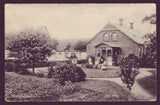 Old postcard from Denmark showing  a family gathered on the front porch of their home.