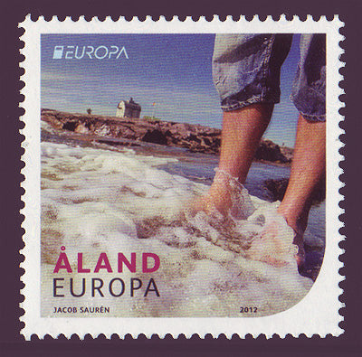 Al;and stamp showing tourist barefoot on the beach.
