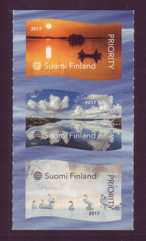Three stamps from Finland 2017 showing  small boat on a lake, clouds in the sky and swans.